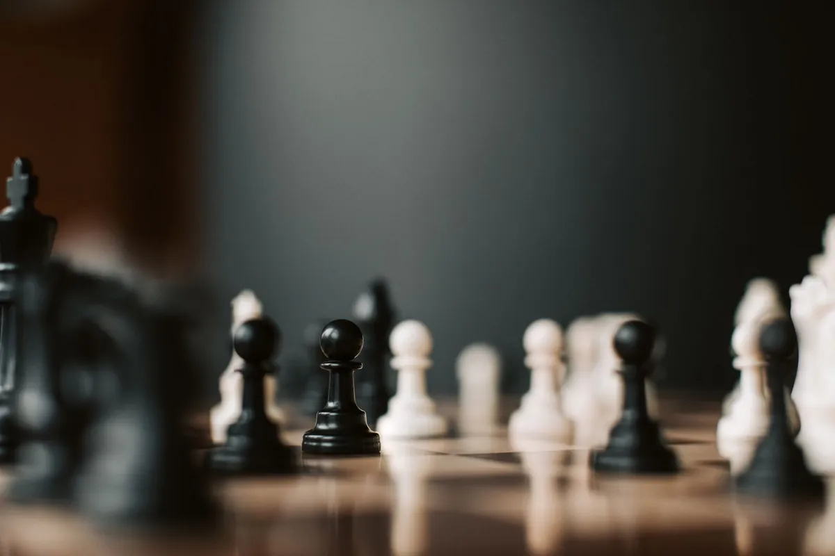 Close-up of black and white chess pawns standing on a chessboard